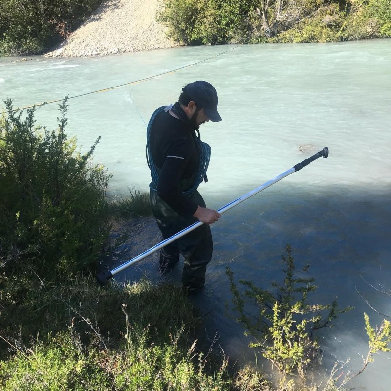 Marcelo Somos-Valenzuela measuring streamflow in a glacial river